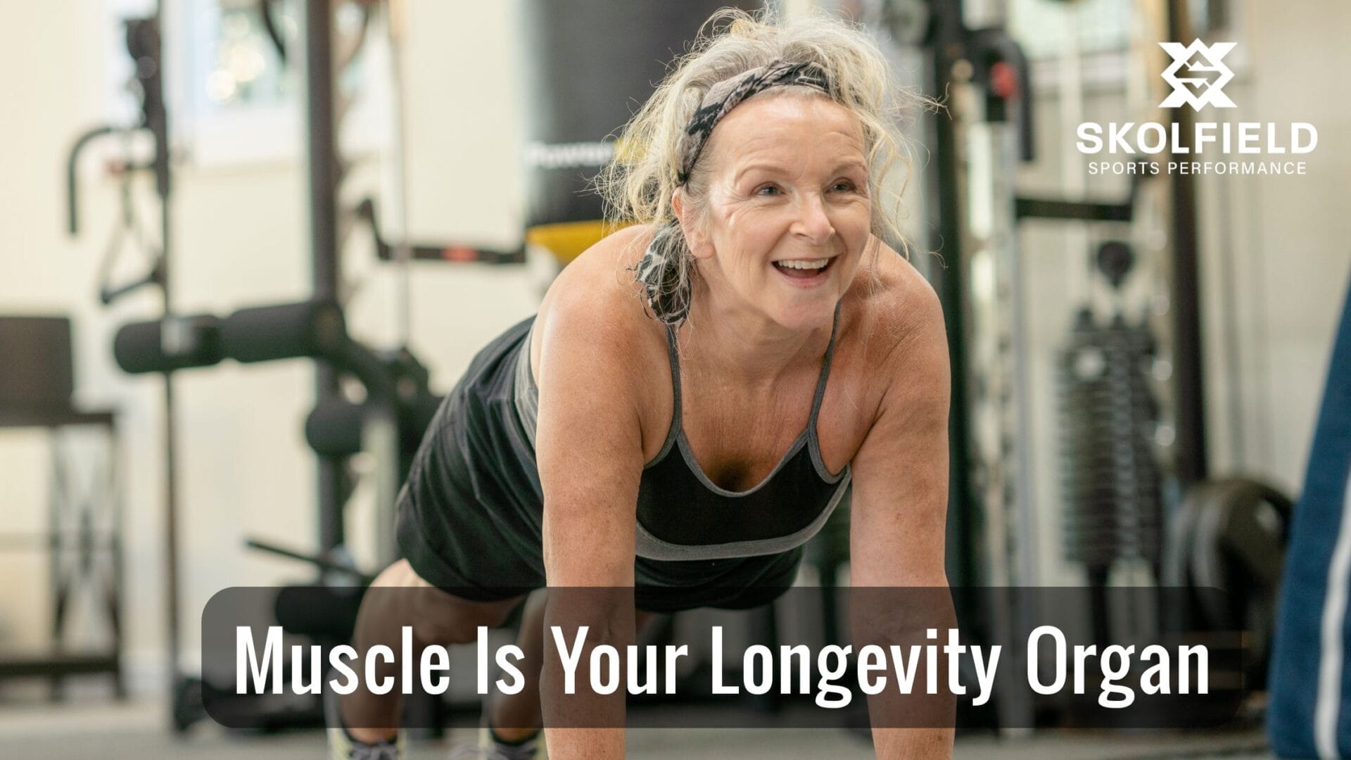 Midlife adult performing a push upwhile a coach cues form, showcasing strength training for longevity and independence